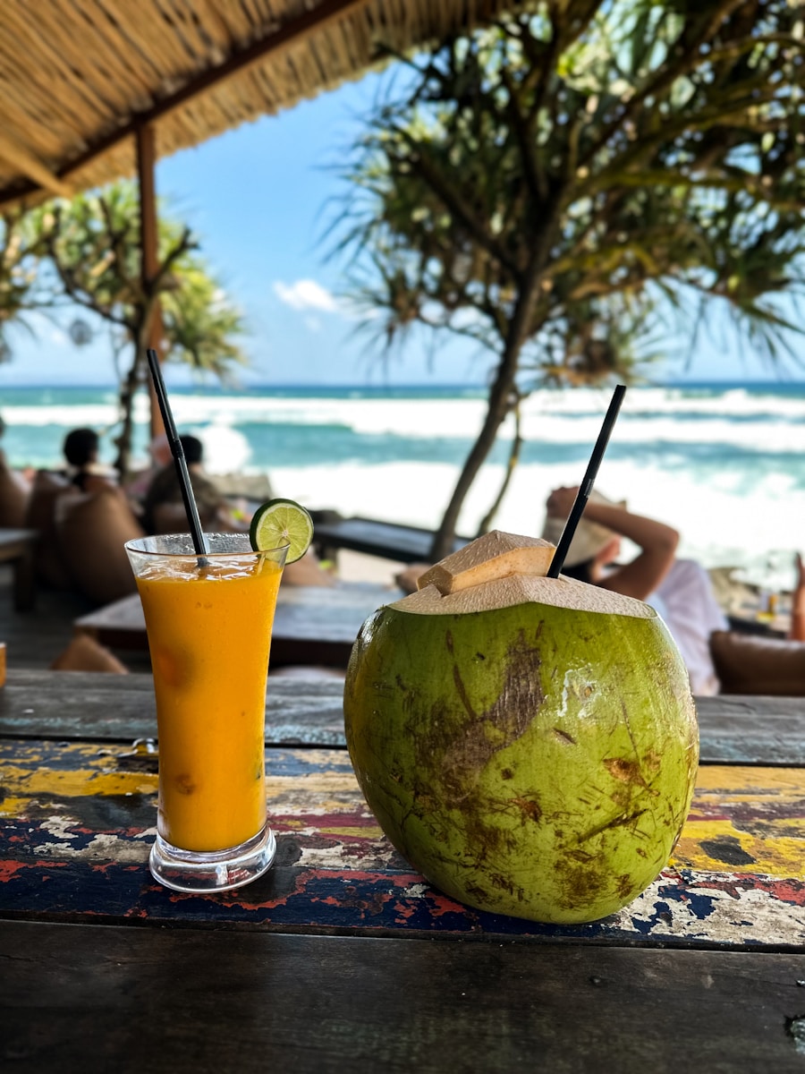 A glass of orange juice next to a coconut on a table